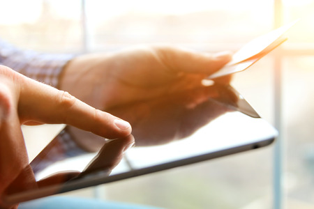 business man entering data of a credit card . On-line shopping on the internet using a tabletの写真素材