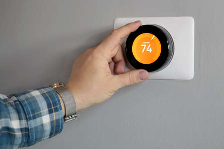 Man is Adjusting a  temperature  in modern living roomの写真素材