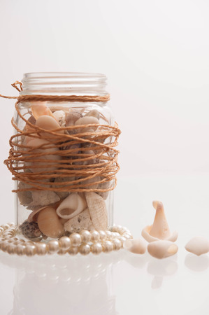 Seashells in a glass container の写真素材