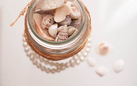 Seashells in a glass container の写真素材