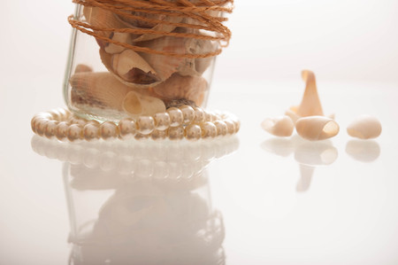 Seashells in a glass container の写真素材