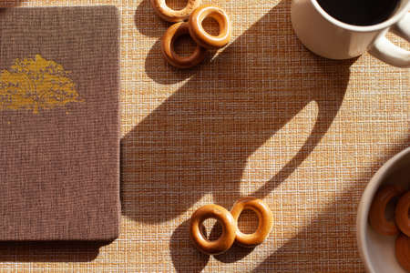 A cup of coffee, barankis, notepad on wooden tableの写真素材