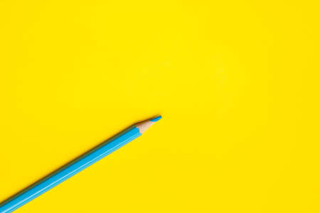 diagonal blue sharp wooden pencil on a bright yellow background, isolated, copy space, mock upの写真素材