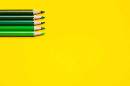 horizontal green sharp wooden pencils on a bright yellow background, isolated, copy space, mock upの写真素材