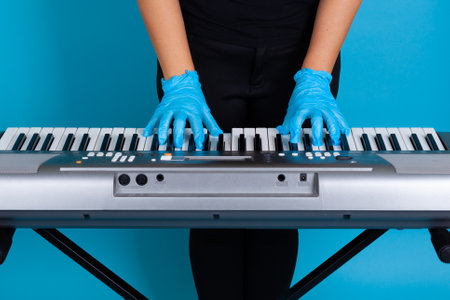 womens hands in blue rubber disposable medical gloves for virus protection under covid-19 isolated on blue backgroundの写真素材