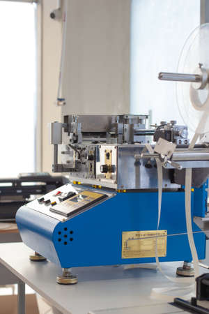 side view professional equipment on the table in factory, blue Chinese cold or hot elastic tape...