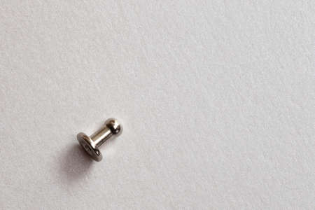 minimalism close-up grommet, rivet, snap, button on the paper silver backgroundの写真素材