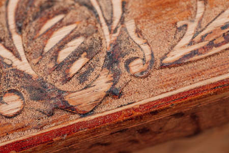 macro dust on an old wooden box with floral monograms from sanding polish, preparation for...