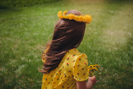 rear view close-up of a girls long hair flowing in the wind with a wreath of dandelions on her head...