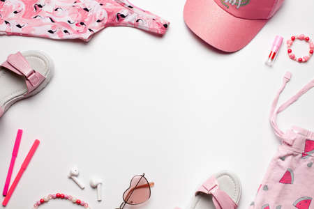Beach fasion composition with girls accessories on white background. Frame design with empty space.