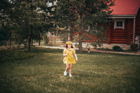 lifestyle full-length portrait of a child running on the grass in the forest on vacation with his...