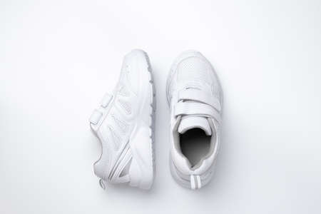 top view two white unisex sneakers, one sneaker is on the side isolated on a white background