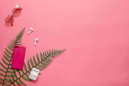 Flat lay with phone accessories and sunglasses. Pink heart-shaped sunglasses and phone accessories...