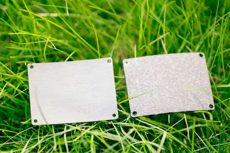 Top view of frame made of green spring grass and two gray leather patches for sale with copy space....