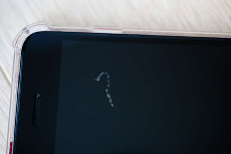Close-up of one short disgusting looking hair in upper part of phone screen close to speaker under...