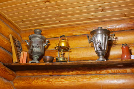 Wooden sauna room with shelf on wall with antique counter, samovar and icon-lamp. Reuse of old things - sustainable actions. Healthy way of spending free timeの写真素材