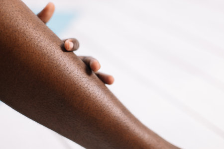 Bare legs of afro american woman closeup, blurred background free copy space. Black person lying...