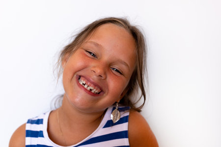 Glad shiny smiling little blonde girl with baby temporary milk crooked teeth. Orthodontic practice...