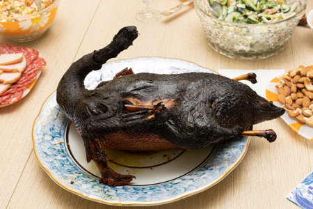Burnt bird carcass on serving dining table. Serve charred spoiled dish. Lousy housewife and bad chef. Delicious cold starters and terrible main course. Disgusting cooking, ruined celebrationの写真素材