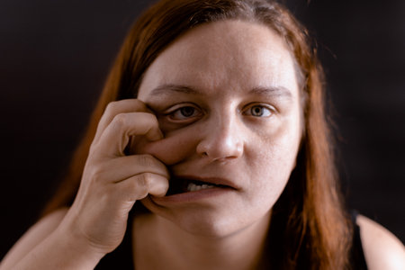 Freaky young woman pulling skin of face to side by fingers. Pain, ugliness over face. Mentally unhealthy person.の写真素材