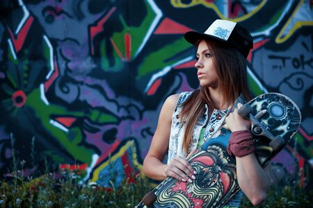 Girl with skateboard on colorful backgroundの写真素材