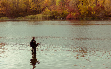 Fisherman fishing. Standing in the water in the Dnieper River in the fallの写真素材
