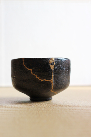 Repair of crack pottery tea cup / verticalの写真素材