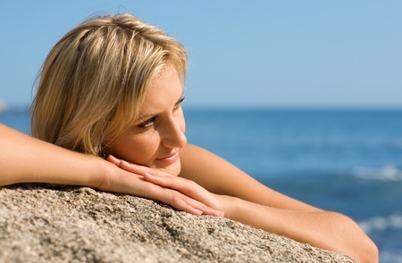 Thoughtful girl on the beach by the sea.の写真素材