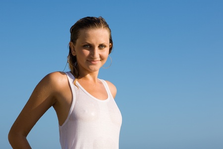 Beautiful girl against the sky after a swim in the seaの写真素材