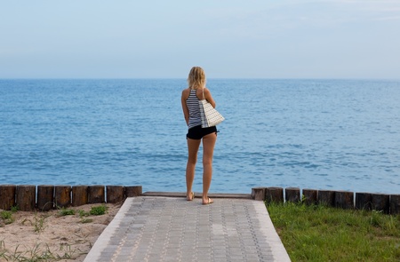Attractive blonde standing on the beach. Evening.の写真素材