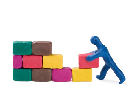A plasticine little bricklayer building a brick wall. の写真素材