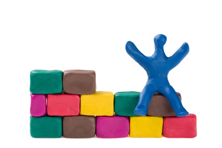 A plasticine little bricklayer building a brick wall. の写真素材