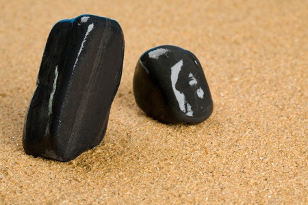 Black stones on the sandの写真素材