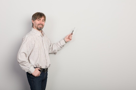 Businessman showing something on a gray background.の写真素材