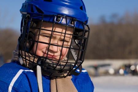 A boy plays hockey on the outdoor ice area. Boy seven years.の写真素材