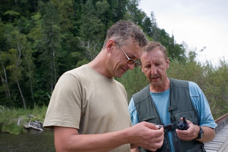 Hikers check the operating status of walkie-talkie in field conditions.の写真素材