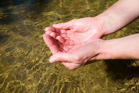 Small river with pure(clean) transparent water. In female hands transparent water.の写真素材