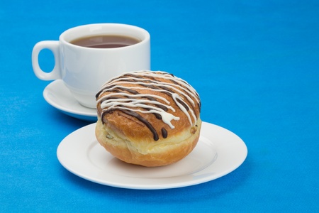 Donut(doughnut) with raisin covered with chocolate and sugar glaze. Cup tea.の写真素材