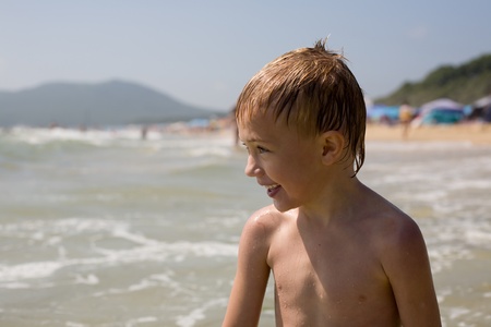 The smiling boy on a beach at the sea. Boy six years.の写真素材