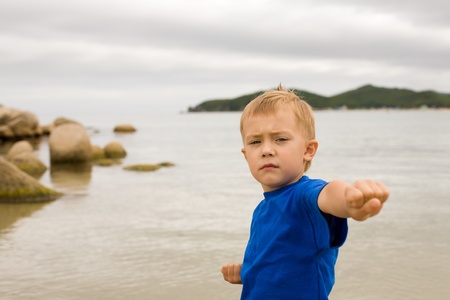 Karate boy in a fighting position on seacoast.Boy 5 years.の写真素材