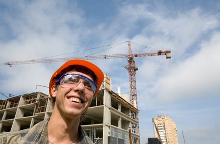 Young builder inspector on a background of building object.