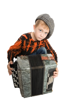 Serious boy with accordion. Studio light.の写真素材