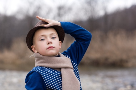 Little boy in a hat fall day along the river.の写真素材