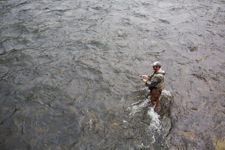 Fisherman catches of salmon on a mountain riverの写真素材
