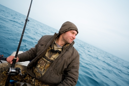 Angler fisherman catches a salmon trolling in the sea.の写真素材