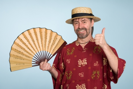 Happy european in traditional chinese shirt with thumbs up gesture.の写真素材