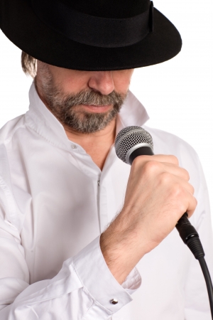 Portrait of a singer with microphone isolated on white. Focus on the microphone.の写真素材