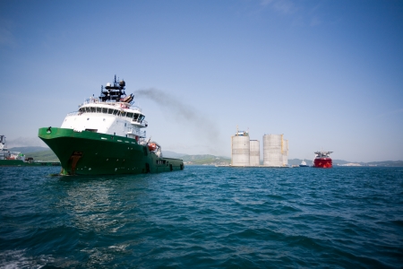 Ocean tugs towing base offshore oil drilling platform. Sea of Japan. Russian coast.の写真素材