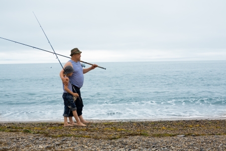 Grandfather and grandson fishing at the weekend at sea.の写真素材