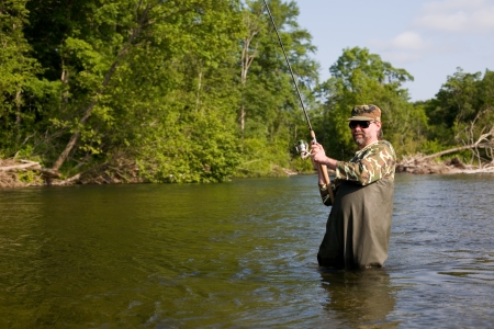 Fisherman pulls caught salmon. River.の写真素材